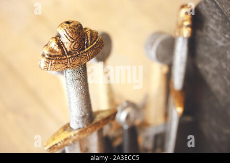 Lot of titan steel metal swords in a pack. Batch of multiple medieval decorations , extreme throne made swords  knights concept , old weapons at marke Stock Photo