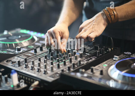 DJ using sound controller to mix music. Selective focus. Stock Photo
