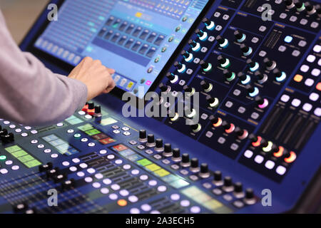 Operator working with professional stage lighting control console. Selective focus. Stock Photo