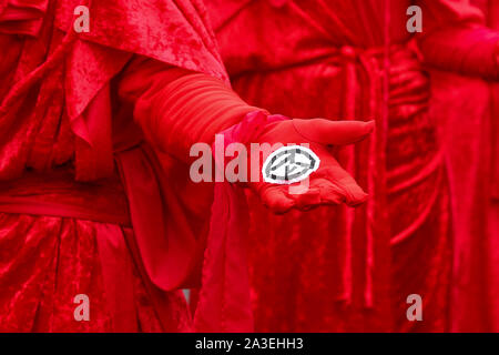London, UK. 07th Oct, 2019. A protester from Extinction Rebellion movement shows a symbol of the group during the demonstration. Credit: SOPA Images Limited/Alamy Live News Stock Photo
