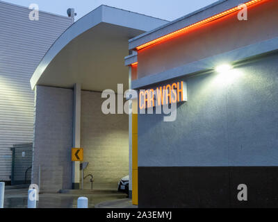 Car emerging from car wash station in evening light Stock Photo