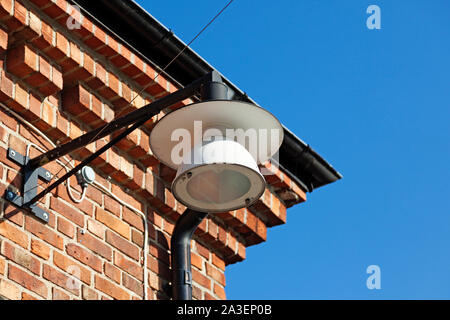 the corner of an old building by the river in Umea and a lamp mounted on the house Stock Photo