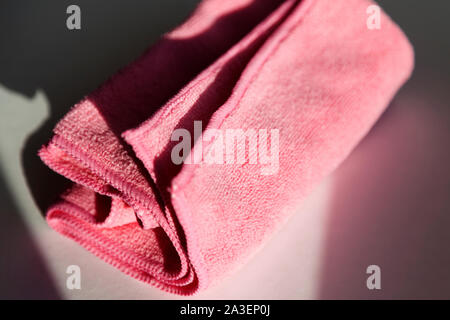 pink cleaning cloth lying in the windowsill at sunset Stock Photo