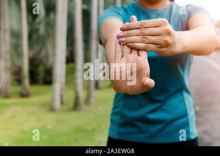 sport woman stretching forearm before exercising. outdoor sport and exercise activities concept Stock Photo