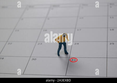 Miniature people thingking salary and looking at down 31 date end of a month. Stock Photo