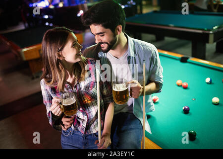 Happy young man playing snooker with his girlfriend. Happy loving couple. Stock Photo