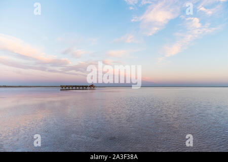 Train with mined salt rides on the surface of the water on the background of a beautiful sunset. Salt lake bursol, burlinskoye village. Altai territor Stock Photo