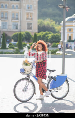 Woman riding bike after going to supermarket Stock Photo