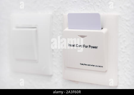Close up view home or hotel room white wall with card reader and card holder for energy saving switch Stock Photo