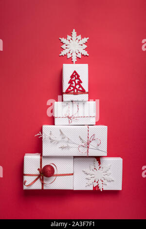 Creatively wrapped and decorated christmas presents in boxes on red background. Top view from above. Flat lay wit copy space , vertical composition Stock Photo