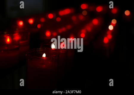 Red candles burning in a row. Church of the Divine Salvador (Capilla de la Pasión), Seville, Andalusia, Spain. Selective focus Stock Photo