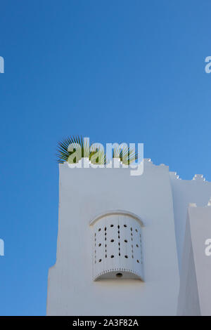 Moroccan white design window upstairs at a plasterd wall in Assilah, Morocco Stock Photo