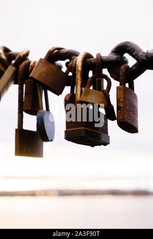 Small padlocks hagning on a chain , symbols of peoples love. Stock Photo