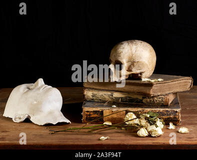 Classical Baroque Still-life in Vantias style with Skull and Death-Mask on a black Background Stock Photo
