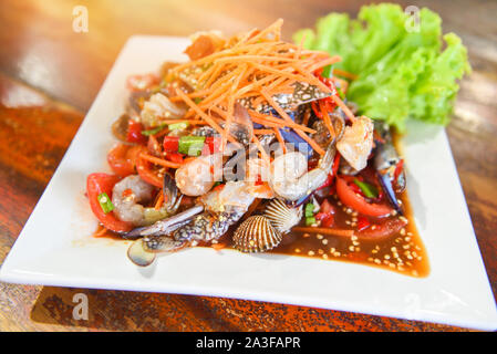 Seafood salad spicy with fresh shrimp crab cockles served on white plate fresh vegetables herbs and spices ingredients with carrot salad lettuce - Som Stock Photo