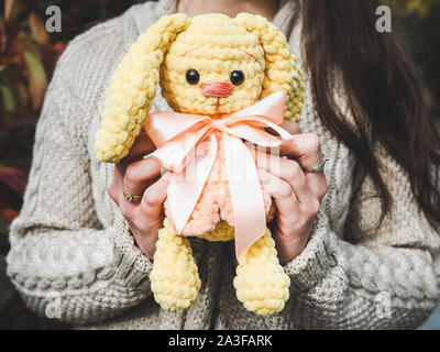 Pretty, young woman holding a stuffed toy in the background of yellow foliage. Close-up, outside Stock Photo