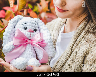 Pretty, young woman holding a stuffed toy in the background of yellow foliage. Close-up, outside Stock Photo