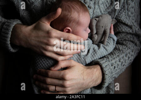 A father holding his baby son on his chest. Family bonding. Fatherhood Stock Photo