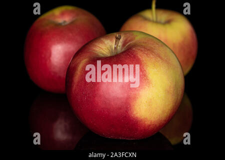 Group of three whole red apple jonagold isolated on black glass Stock Photo