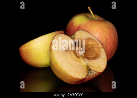 Group of one whole two rotten halves of jonagold red apple isolated on black glass