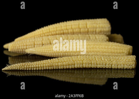 Lot of whole one half of baby yellow corn isolated on black glass Stock Photo
