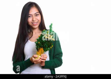 Studio shot of young happy Asian teenage girl smiling while hold Stock Photo