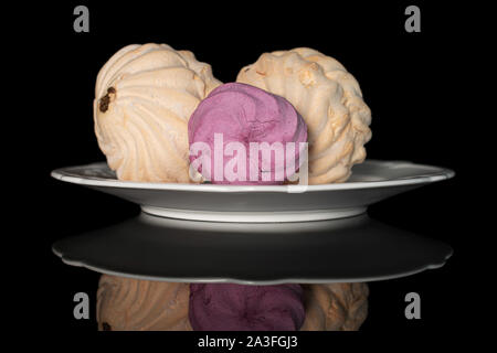 Group of three whole fresh pastel zefir on white plate isolated on black glass Stock Photo