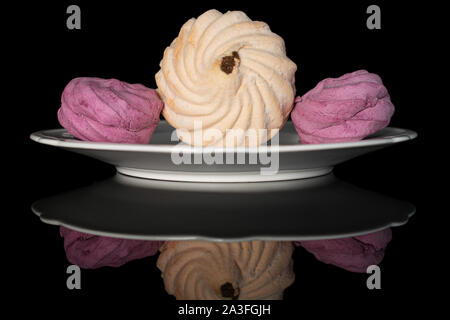 Group of three whole fresh pastel zefir on white plate isolated on black glass Stock Photo