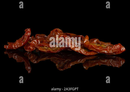 Lot of slices of dry red cherry tomato isolated on black glass Stock Photo