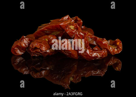 Lot of slices of dry red cherry tomato heap isolated on black glass Stock Photo