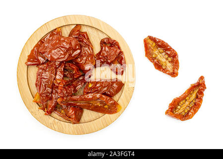 Lot of slices of dry red cherry tomato on bamboo plate flatlay isolated on white background Stock Photo