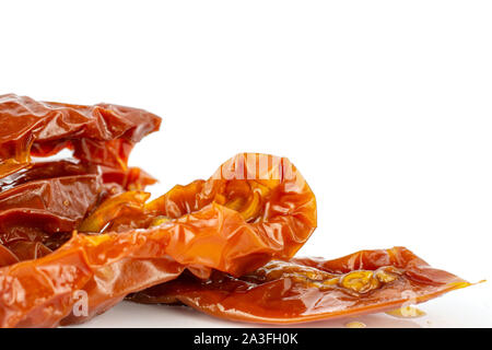 Lot of slices of dry red cherry tomato closeup isolated on white background Stock Photo