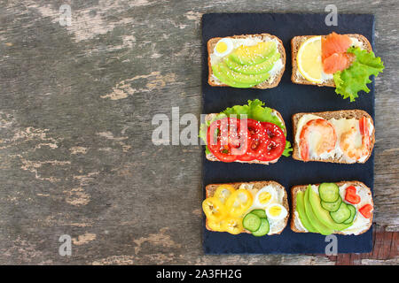 Different sandwiches on old wooden background. Top view. Flat lay. Stock Photo