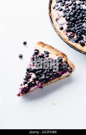 Summer tart with fresh blueberries, one wedge cut Stock Photo