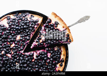 Summer tart with fresh blueberries, one wedge cut Stock Photo