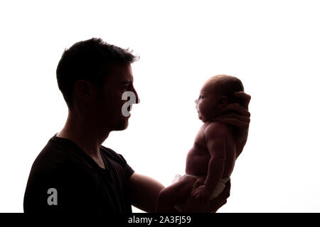 Silhouette of a father holding his newborn baby Stock Photo