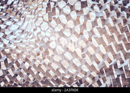 Abstract background made of perforated brown paper, selective focus, color toning applied. Stock Photo