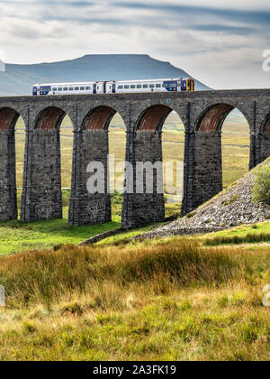 Train crossing the Ribblehead Viaduct with Ingleborough beyond Yorkshire Dales National Park England Stock Photo