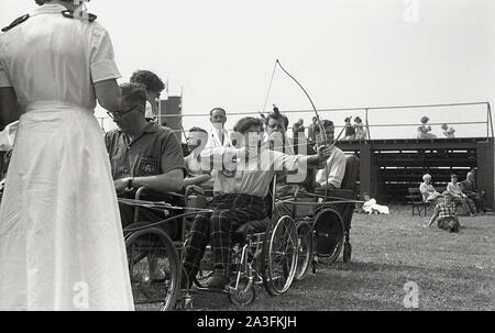 1950s, historical, Stoke Mandeville games, adult competitors in wheelchairs taking part in the archery competition. The games at the hospital had been established by Dr Guttmann in 1948 involving WW2 veterans with spinal injuries and are considered the first Paralympic Games. Stock Photo