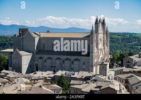 A view across the rooftops of Orvieto in Umbria, towards the gothic cathedral dedicated to the Assumption of the Virgin Mary. Stock Photo