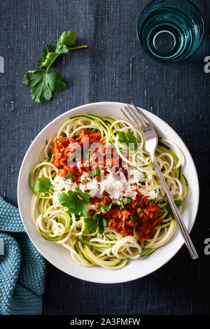 keto paleo zoodles bolognese: zucchini noodles with meat sauce and parmesan Stock Photo