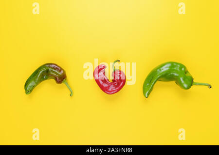 Trendy Ugly red chilli peppers on yellow background, minimal nature style, pop-art, creative food concept Stock Photo