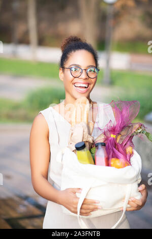 Positive excited woman coming back home from supermarket Stock Photo
