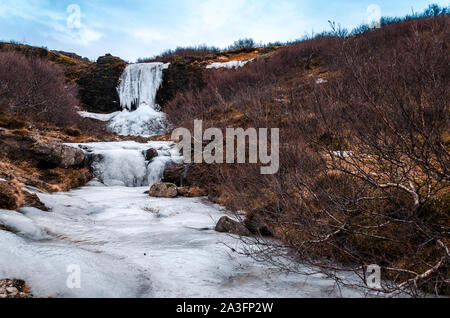 Frozen cascading waterfall from the meltwaters of Icelandic glaciers Stock Photo