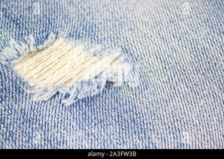 Ripped destroyed in wash blue denim jeans. isolated background Stock Photo