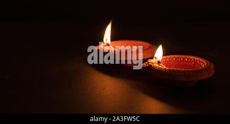 Diwali, Hindu festival of lights. Clay diyas candles illuminated in Dipavali. Oil lamps on traditional tray, copy space Stock Photo