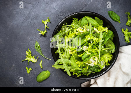 Green salad leaves mix on black top view. Stock Photo