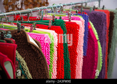 Multi-colored rugs. Carpet, rug, blanket. Abstract striped background of new home multi-colored door carpets for home with a textile texture. Stock Photo