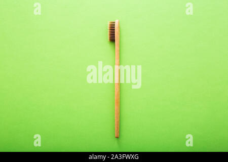Dental care with eco friendly bamboo toothbrush on green background top view. Zero waste and plastic free concept. Stock Photo
