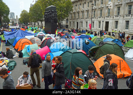 Extinction Rebellion (XR) protesters camp in tents around the Monument to the Women of World War II on Whitehall in Westminster, central London, as the climate change protest continued into a second day. Stock Photo